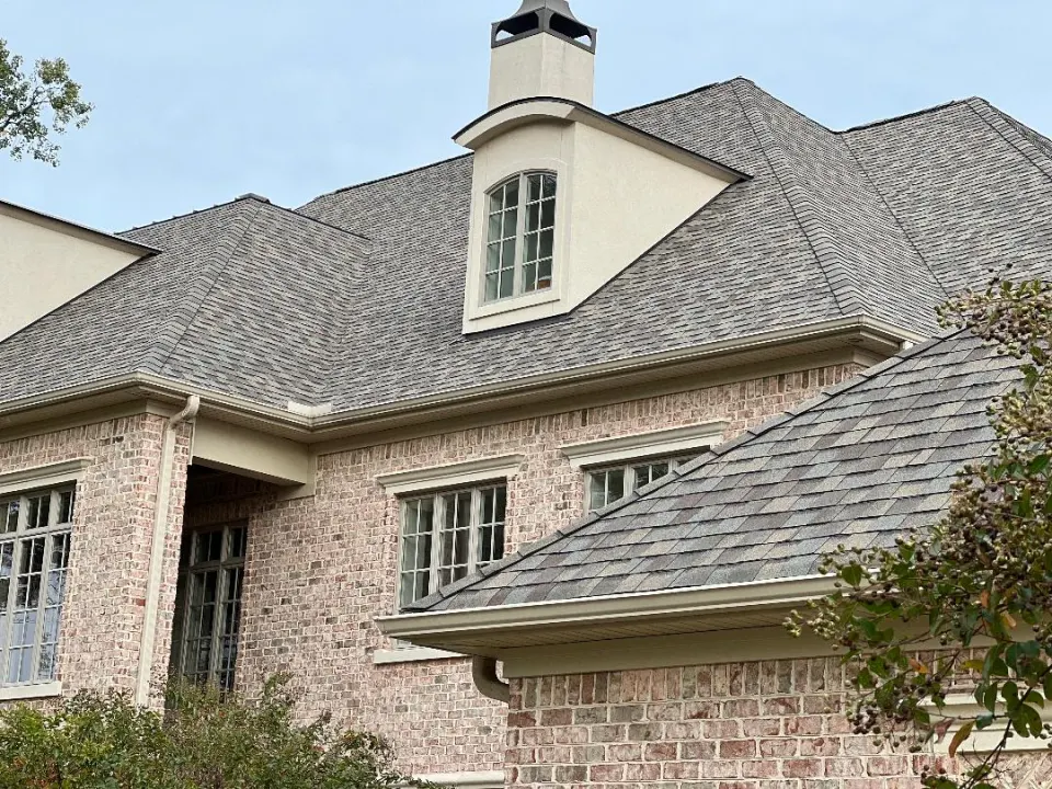 Two-story brick home with a new shingle roof and dormer