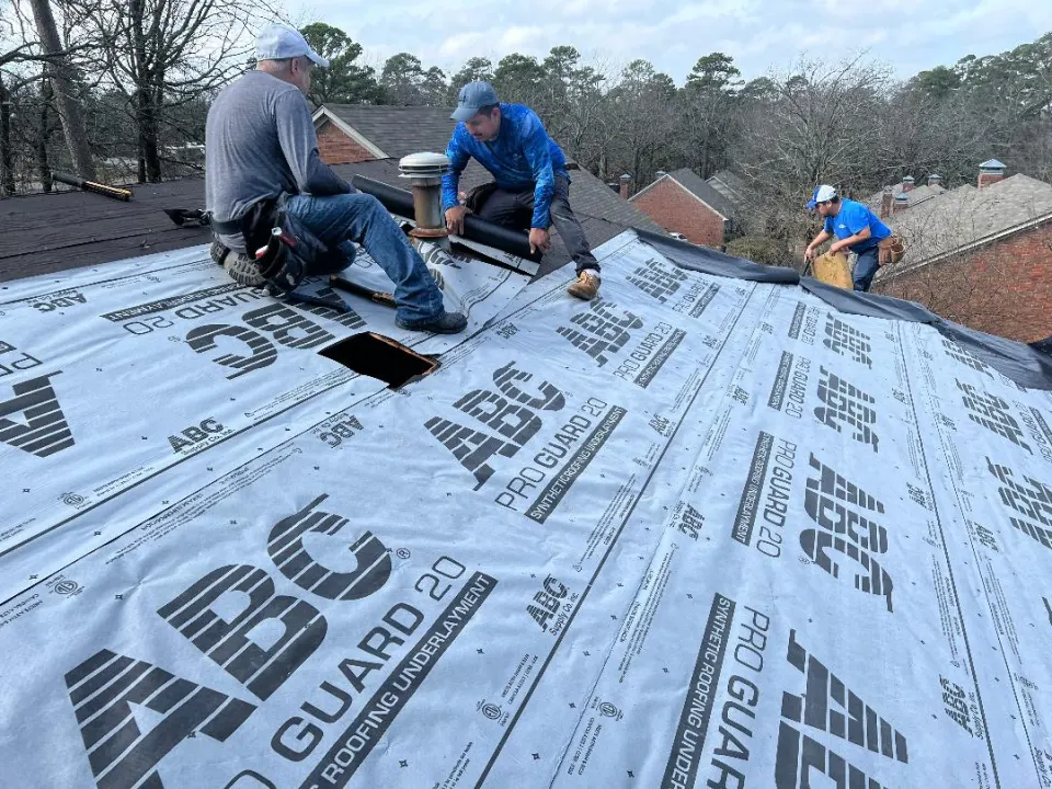 Crew installing synthetic underlayment before shingles